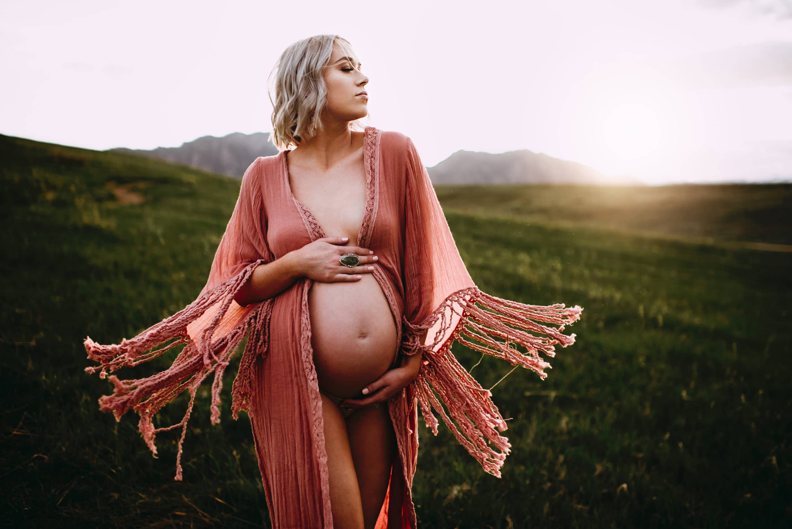 Maternity Photographer, a pregnant woman walks confidently in grassy field